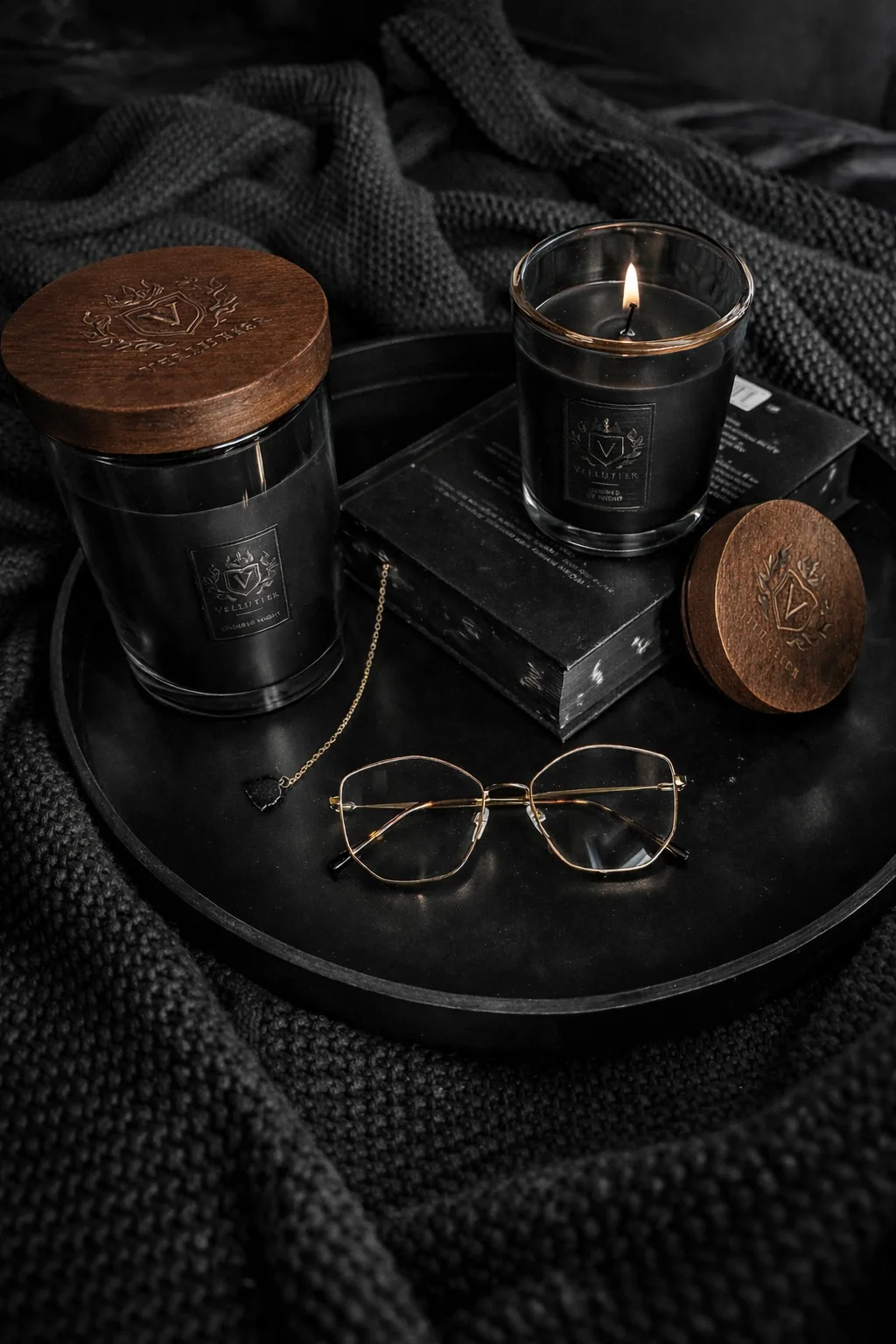 VELLUTIER candles with dark wax and wooden lids on a black tray